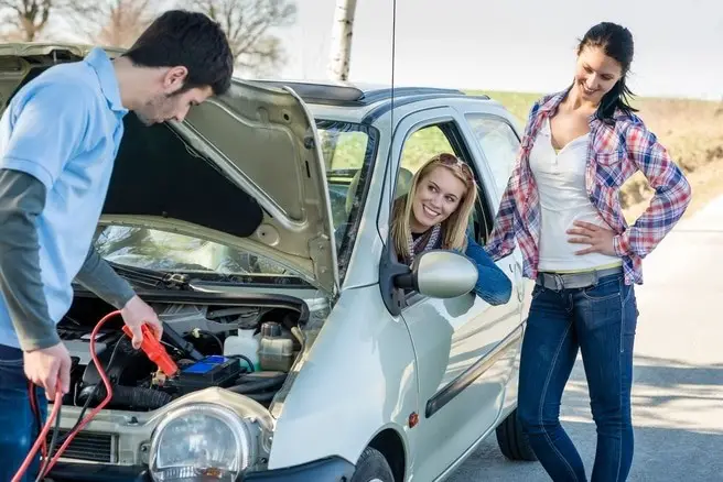 Connecting jump cable to the dead vehicle battery.